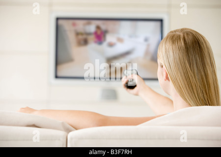 Donna in soggiorno a guardare la televisione Foto Stock