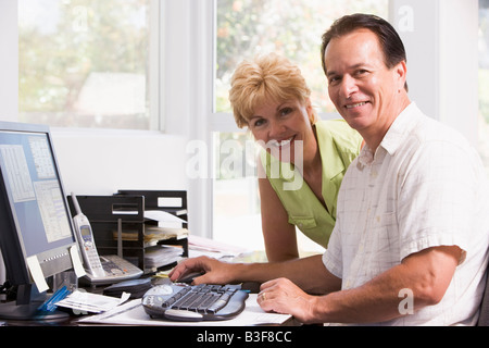 Matura in home office presso computer sorridente Foto Stock
