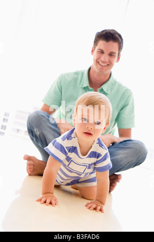 Padre e baby indoor giocando e sorridente Foto Stock