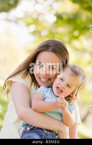 Madre figlia di contenimento esterno sorridente Foto Stock