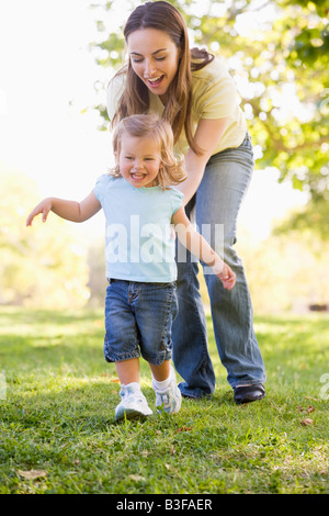 Madre e figlia giocare all'aperto sorridente Foto Stock