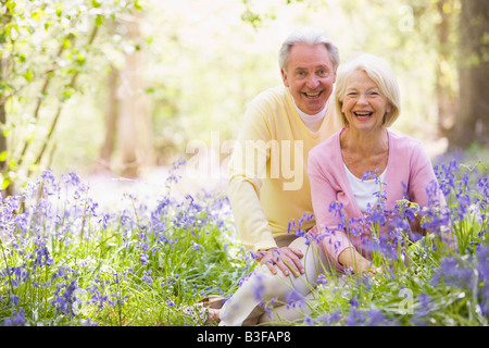 Giovane seduti all'aperto con fiori sorridenti Foto Stock