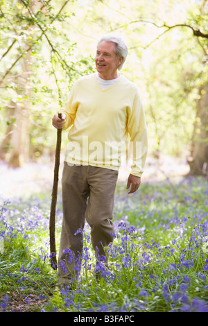 Uomo che cammina all aperto con bastone sorridente Foto Stock