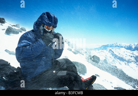 L'alpinista esposta al vento forte e neve sulle rocce Pastuckhov a 4690m sul normale percorso verso la vetta del Monte Elbrus Foto Stock