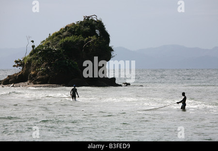 Uomini dominicana la pesca nei pressi di una solitaria isola nella baia di Samana Bay nei pressi di Santa Barbara de Samana, Repubblica Dominicana Foto Stock