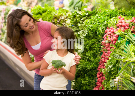Madre e figlia dello shopping di broccoli presso un negozio di alimentari Foto Stock