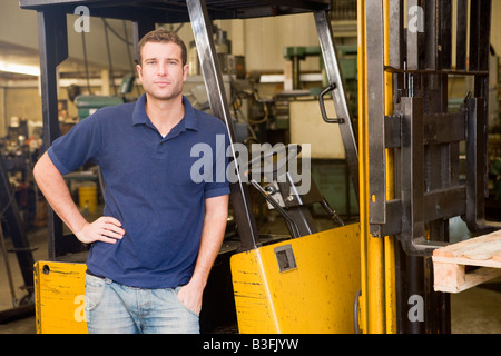 Magazzino permanente del lavoratore con elevatore a forche Foto Stock