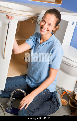 Lavoro idraulico sul lavandino sorridente Foto Stock