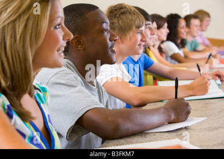 Gli studenti nella classe prestando attenzione e prendere appunti (messa a fuoco selettiva) Foto Stock