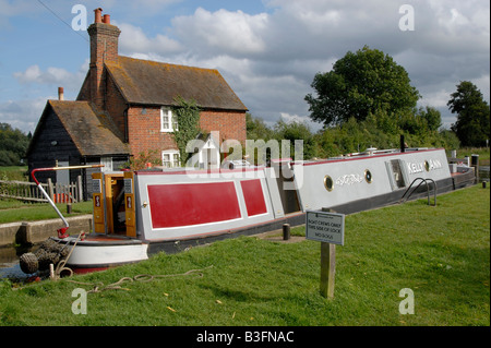 Narrowboat tradizionale passando attraverso il blocco Triggs sul fiume Wey Navigation vicino a Woking, Surrey, Inghilterra Foto Stock