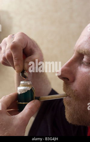 Uomo di fumare una tubazione crack Foto Stock