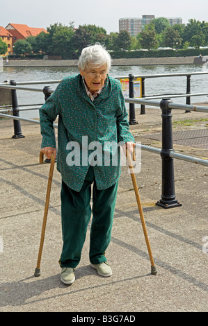 Anziani attivi Inglese 92 anno vecchia donna camminare con due canne da Bristol City docks Foto Stock