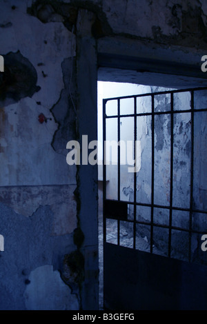 Una vecchia prigione abbandonati cella con barra in metallo porta Foto Stock