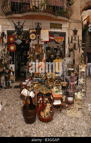 Bric-a-brac e di antiquariato estendersi sulla strada di ciottoli della città vecchia a Malcesine, Garda, Italia. Ritratto. Foto Stock