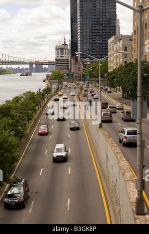 FDR Drive sulla Upper East Side di Manhattan a fianco della East River con il Queensboro Bridge in background Foto Stock