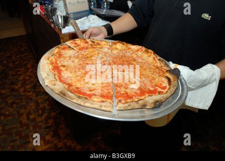 Cameriere serve una pizza a Patsy s Restaurant in East Harlem in New York Foto Stock