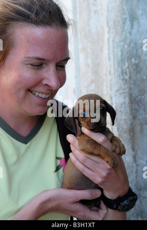 Giovane donna sorridente tenendo un cucciolo provincia di Villa Clara Cuba Aprile 2007 Foto Stock