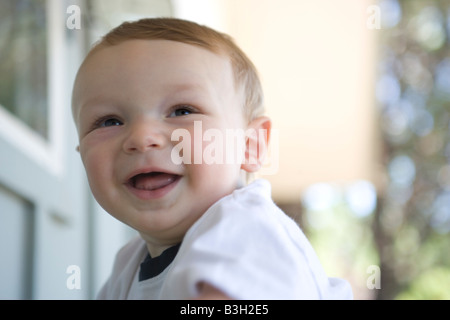 Chiudere fino a otto mesi a sorridere all'aperto, fiducia, gioia, risate Foto Stock