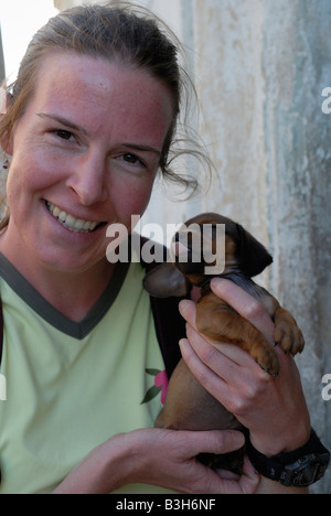 Giovane donna sorridente tenendo un cucciolo provincia di Villa Clara Cuba Aprile 2007 Foto Stock