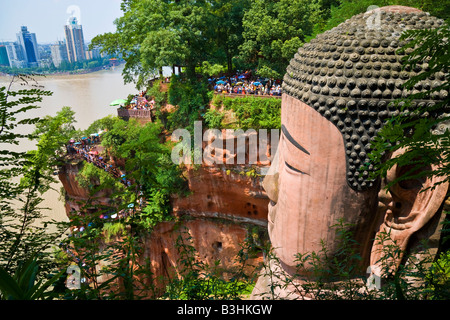 Buddha di Leshan Dafo nella provincia del Sichuan in Cina con Leshan city città sul fiume in background JMH3236 Foto Stock