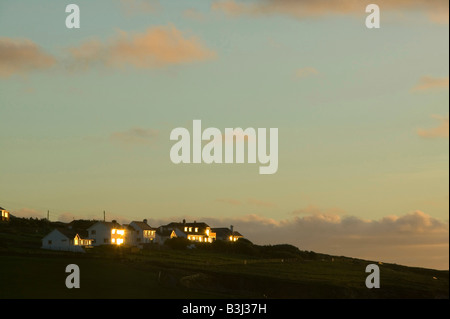 Casa windows che riflette il sole di setting in Polzeath Cornwall Regno Unito Foto Stock