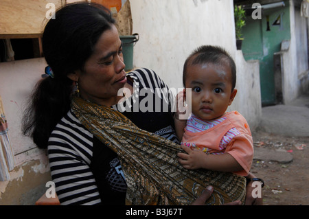 Madre con bambino, baraccopoli zona di kuta , bali , Indonesia Foto Stock