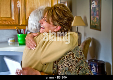 Un felice donna iraniana abbraccia una visita di valutazione a una festa di compleanno in Mission Viejo California nota biglietto di auguri di compleanno in mano Foto Stock