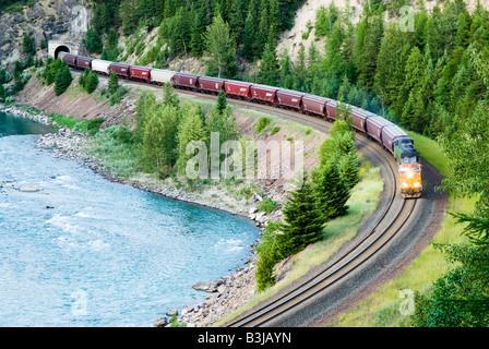 Un diesel elettrico treno merci in uscita un tunnel nelle montagne del Montana lungo la parte centrale della forcella del fiume a testa piatta Foto Stock
