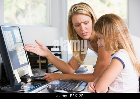 Donna e bambina in home office con computer cercando infelice Foto Stock