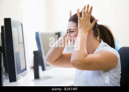 La donna nella sala computer cercando frustrato Foto Stock