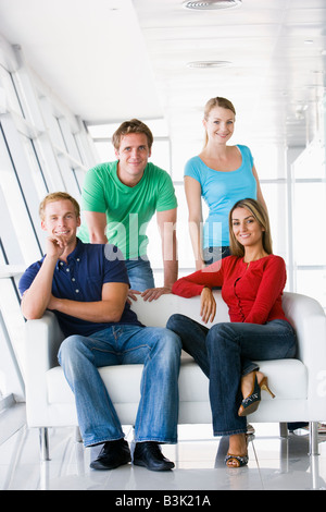 Quattro persone nel lobby e sorridente Foto Stock