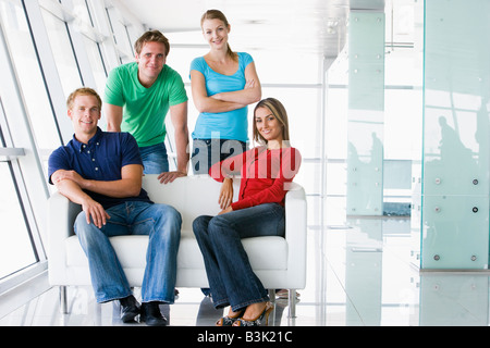 Quattro persone nel lobby e sorridente Foto Stock