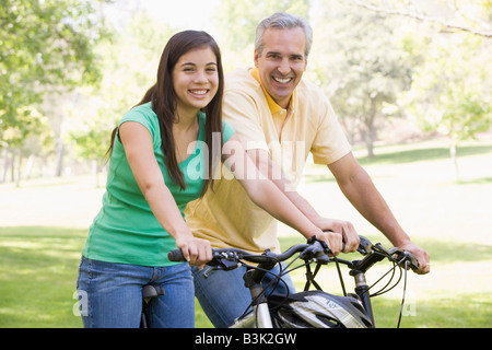 L uomo e la ragazza sulla moto sorride all'aperto Foto Stock