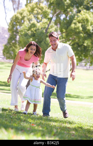 Famiglia correndo all'aperto sorridente Foto Stock