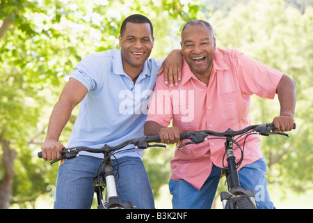 Due uomini su moto sorride all'aperto Foto Stock