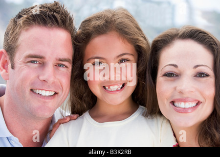 La famiglia sorride all'aperto Foto Stock