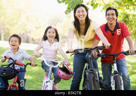 Famiglia sulla bici all'aperto sorridente Foto Stock