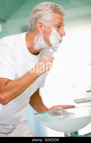 L'uomo in bagno la rasatura Foto Stock