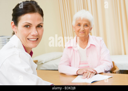 Donna nell'ufficio del medico sorridente Foto Stock