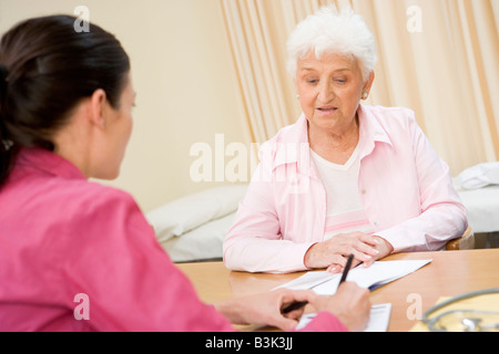 Donna nell'ufficio del medico accigliata Foto Stock