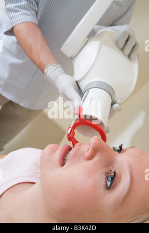 Dentista in sala esame con la donna in sedia Foto Stock