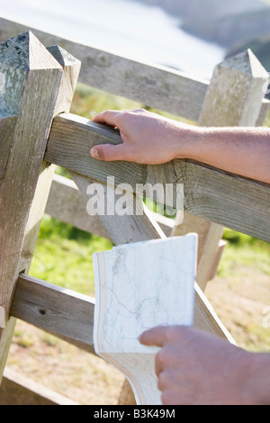 L'uomo le mani sul recinto azienda mappa Foto Stock