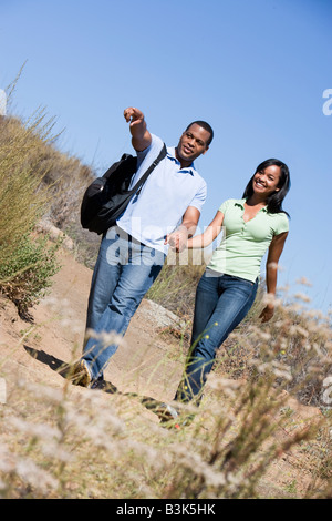 Giovane camminando sul sentiero tenendo le mani e sorridente