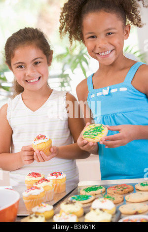 Due bambini in cucina decorare i cookie sorridente Foto Stock