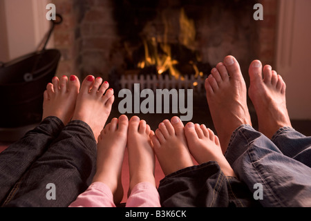 Famiglia di piedi riscaldamento a camino Foto Stock