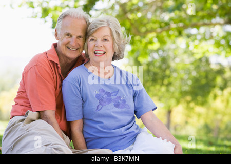Coppia senior seduti all'aperto Foto Stock