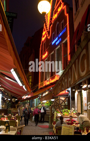 Illuminati al neon esterni di ristoranti lungo la Rue des Bouchers, Bruxelles Belgio Foto Stock