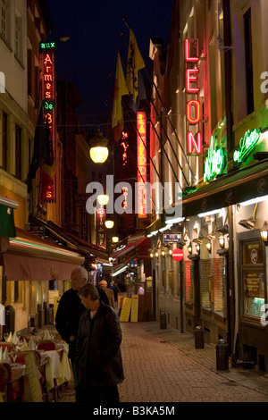 Illuminati al neon esterni di ristoranti lungo la Rue des Bouchers, Bruxelles Belgio Foto Stock