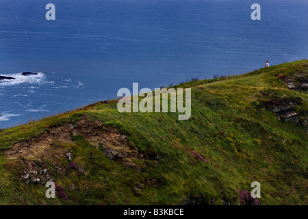 tourist sitting enjoying view of North Cornwall at Crackington Haven Foto Stock