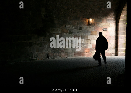 Stagliano uomo a camminare attraverso la porta medievale di Norimberga, Germania Foto Stock